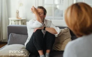 Persona llorando en el sofá mientras otra la acompaña, escena que representa cómo hacer sentir mejor a alguien que está llorando.