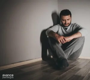 Hombre con expresión triste sentado en el suelo, símbolo del trastorno depresivo mayor