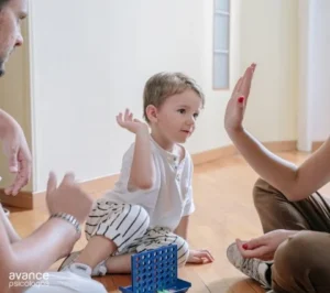 Niño jugando con personas adultas en el suelo, mostrando complicidad y afecto familiar en un entorno de estilo permisivo de crianza