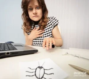 Mujer asustada al ver el dibujo de una cucaracha en la mesa por la fobia a las cucarachas o blatofobia