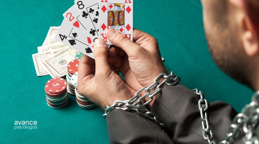 Hombre encadenado jugando al póker con fichas y billetes, simbolizando la adicción al juego o ludopatía.