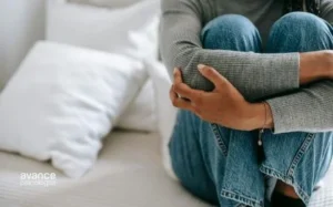 Persona abrazando sus piernas en la cama, símbolo de ansiedad por separación en adultos