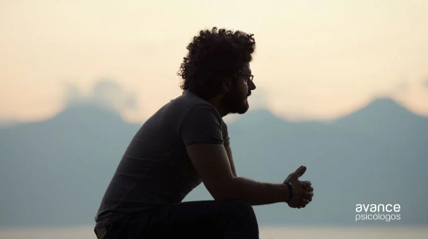 por que no tengo amigos: hombre joven en silueta, sentado y pensativo al atardecer