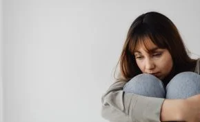 Mujer sentada mostrando abatimiento y falta de energía.