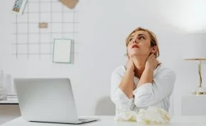 Mujer con estrés laboral en oficina necesitando apoyo psicológico para empresas en Madrid